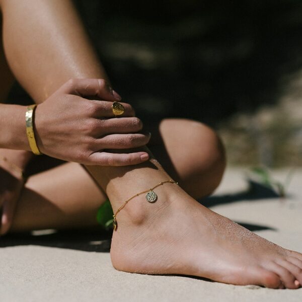 close up of woman’s anklet wearing the truth anklet in gold